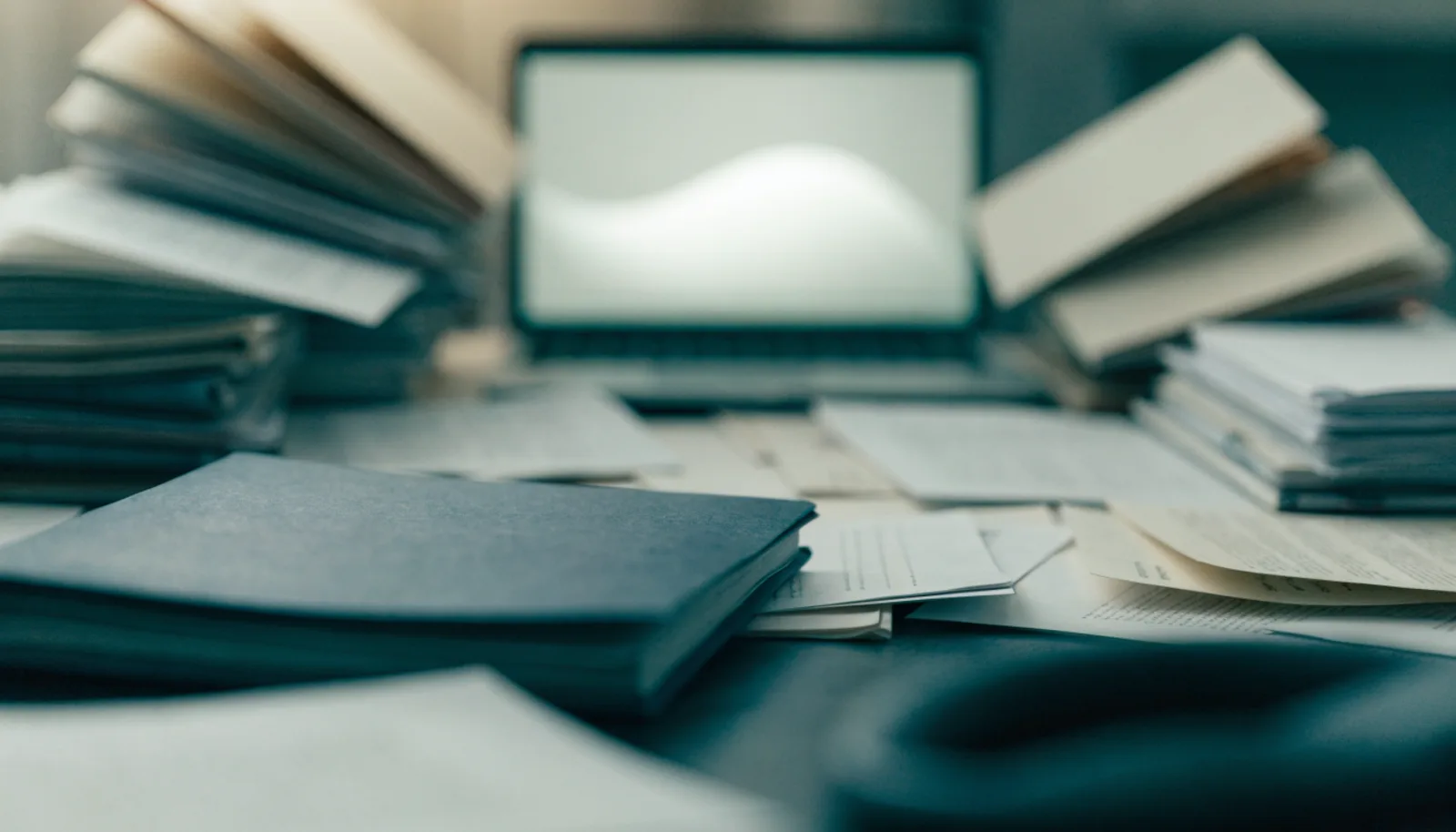 Scattered paper records converging and resolving into a single clean glowing record on a laptop screen